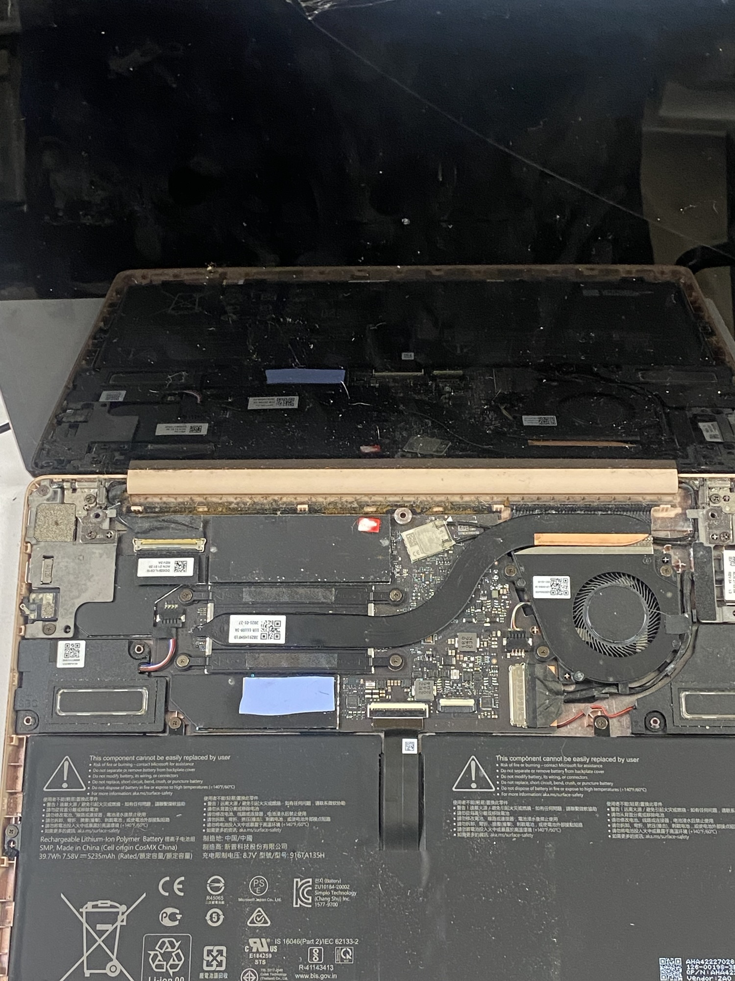 Interior of a dusty laptop showing fans, hard drive, battery, and motherboard components, highlighting the need for cleaning and maintenance